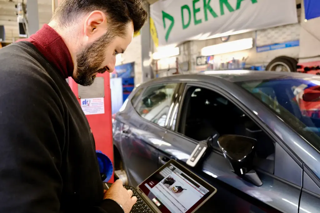 Kfz-Mechatroniker Andre Kasten liest mit dem Diagnosegerät die Daten eines Autos aus